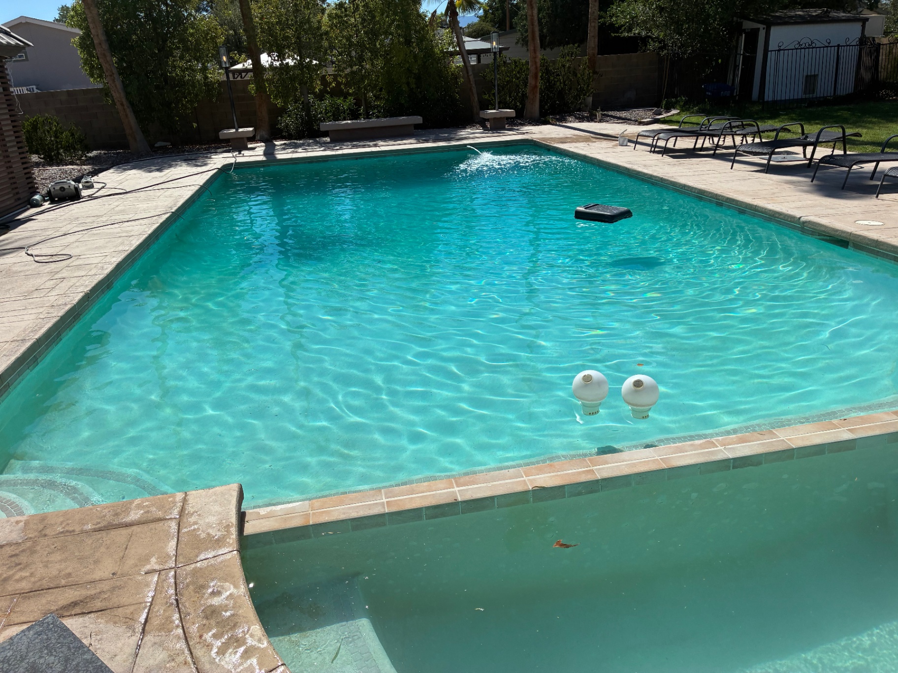 Poolscape with landscape lighting and surrounding hardscape