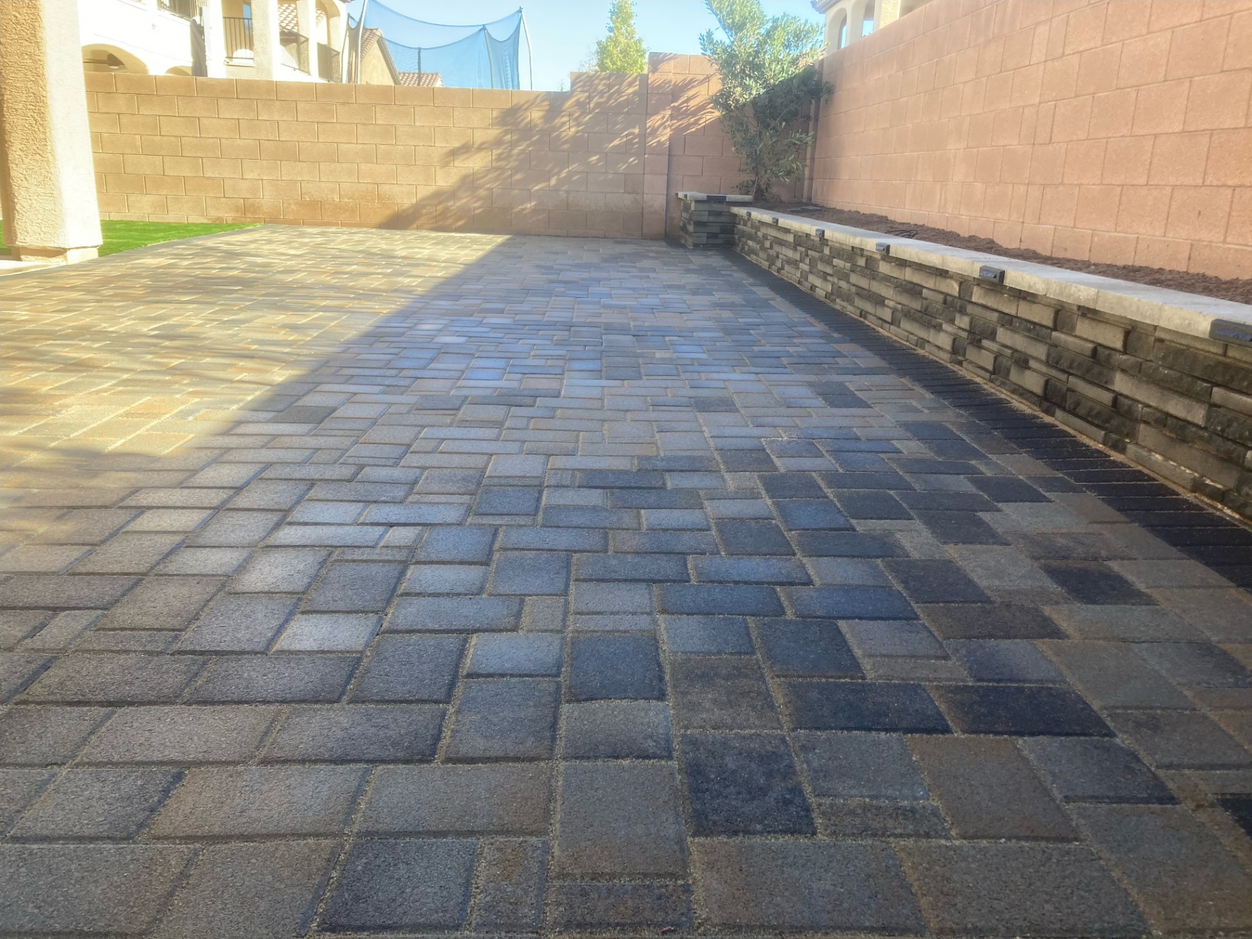 Finished paver courtyard with raised planter wall and seat cap