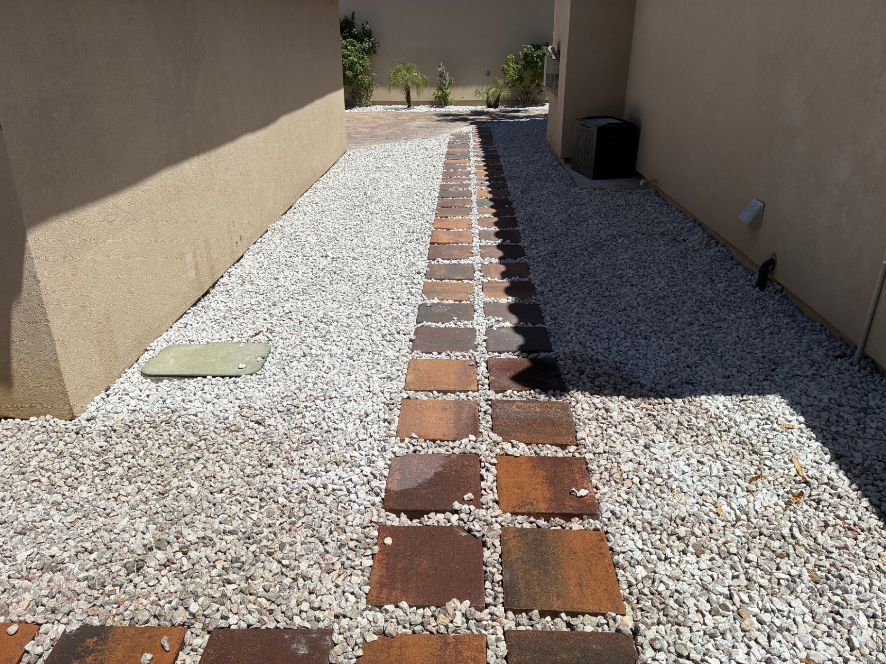 Desert side yard with steel stepping stones and rock ground cover