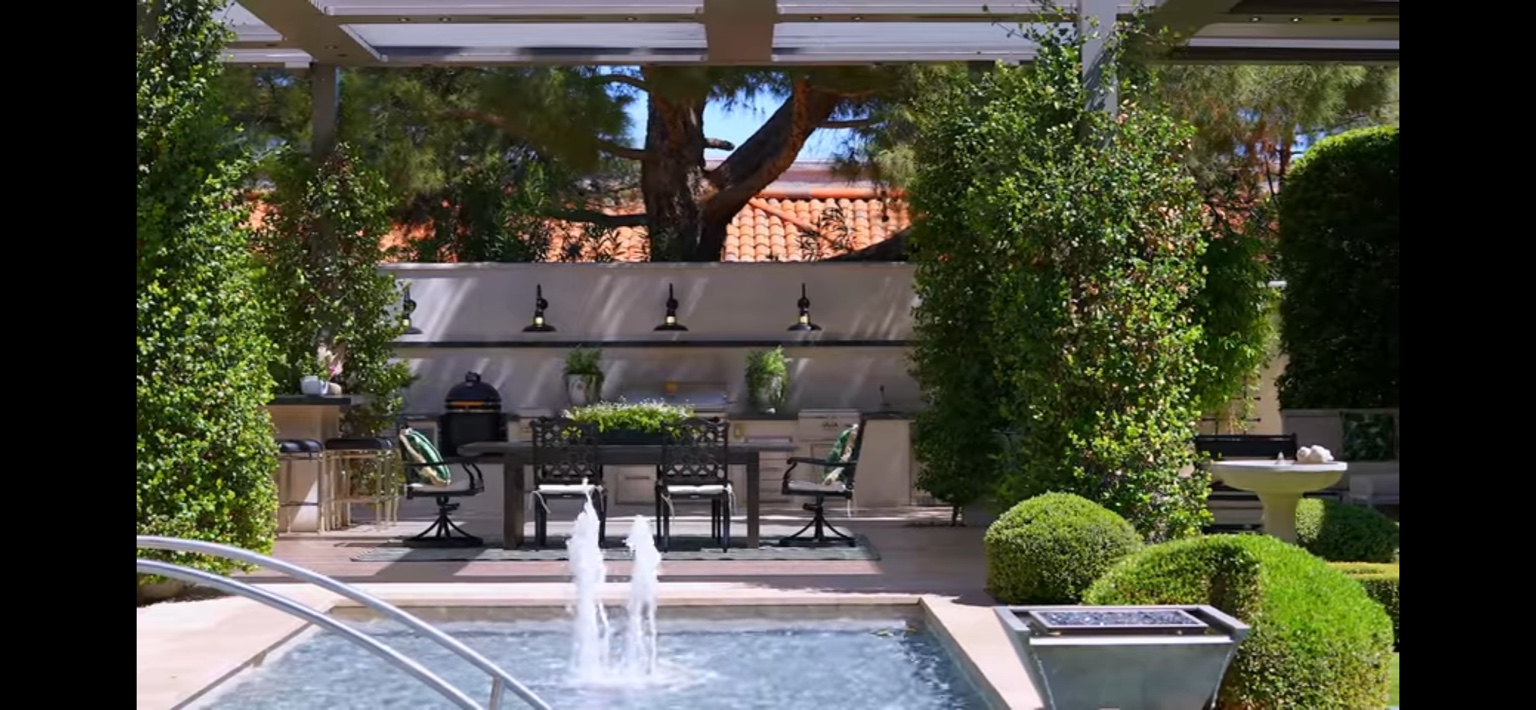 Courtyard fountain, outdoor kitchen, and sculpted estate greenery