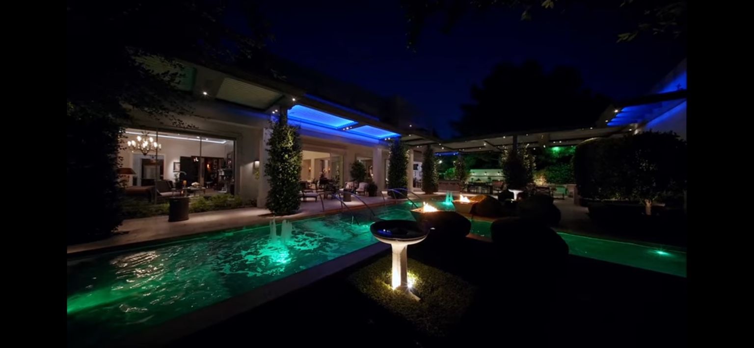 Estate pool and gardens illuminated at night