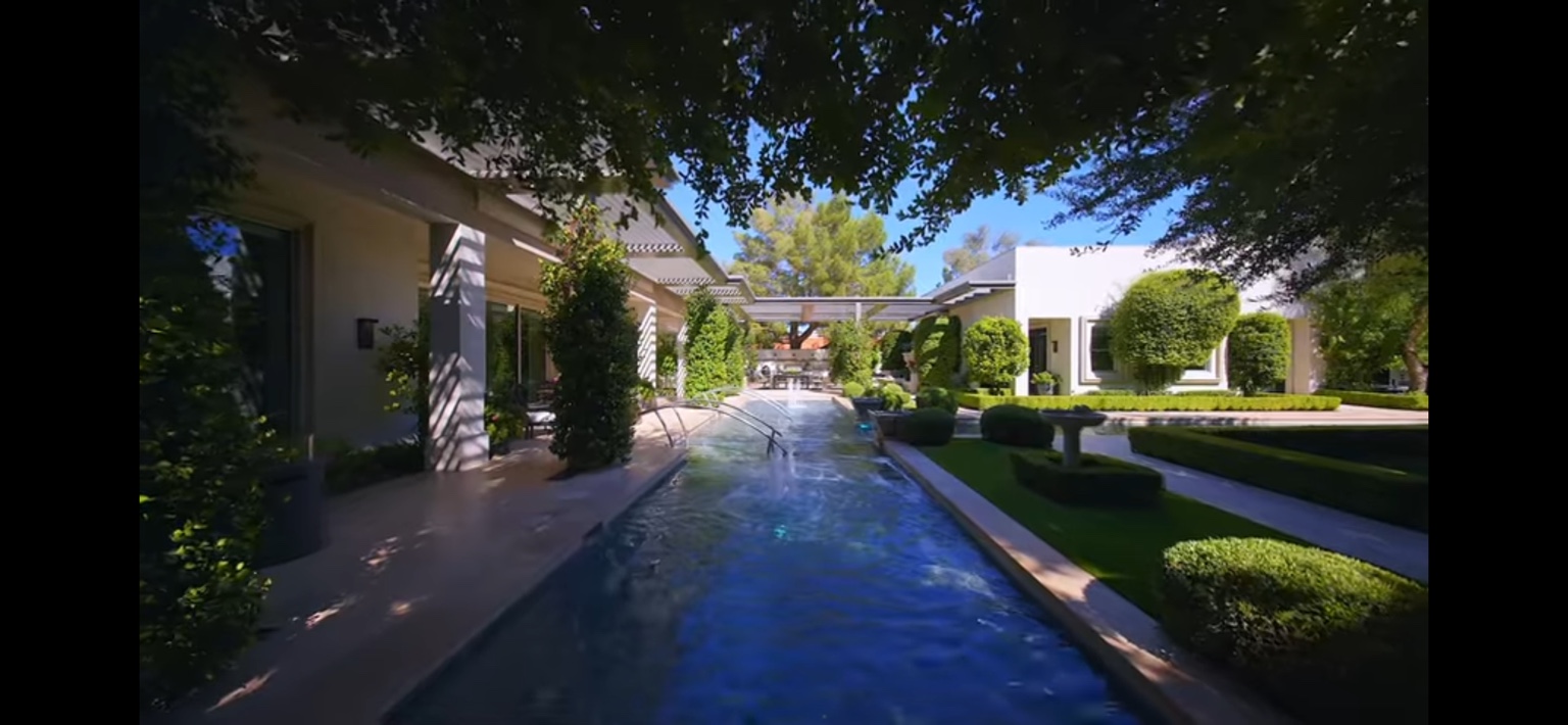 Long estate reflecting pool bordered by lawn and mature trees