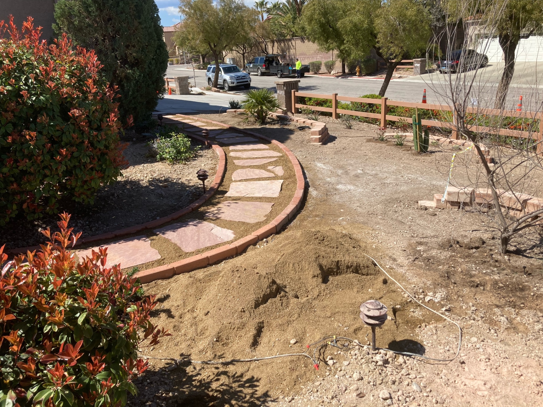 Curved flagstone walkway with brick borders winding through the front yard