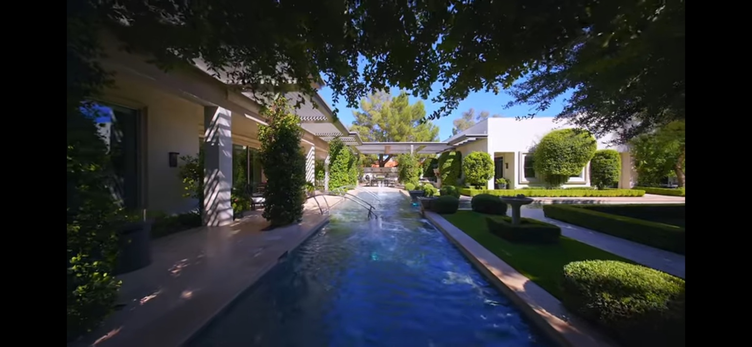 Estate water feature surrounded by manicured lawn and topiary